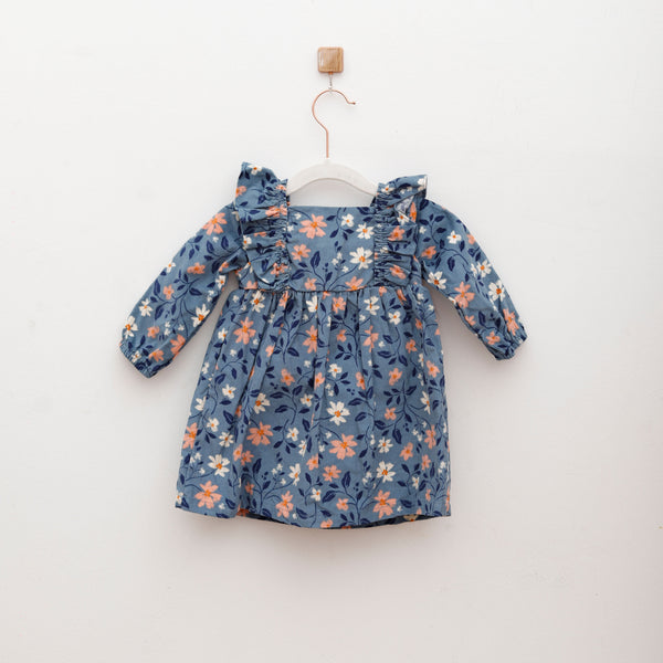 Blue floral dress on a hanger against a white background