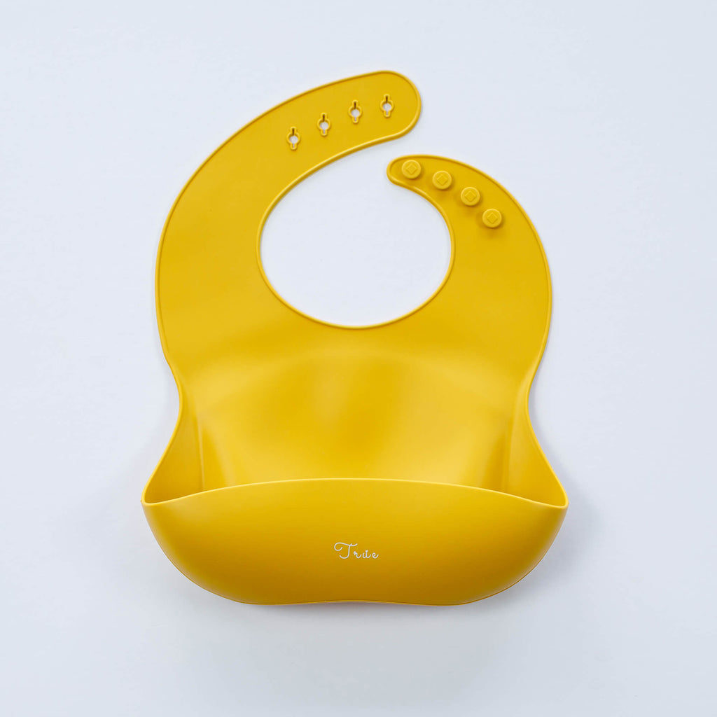 A yellow, BPA-free Silicone Bucket Bib with an adjustable neck strap featuring snap buttons. The bib has a scoop at the bottom to catch food.