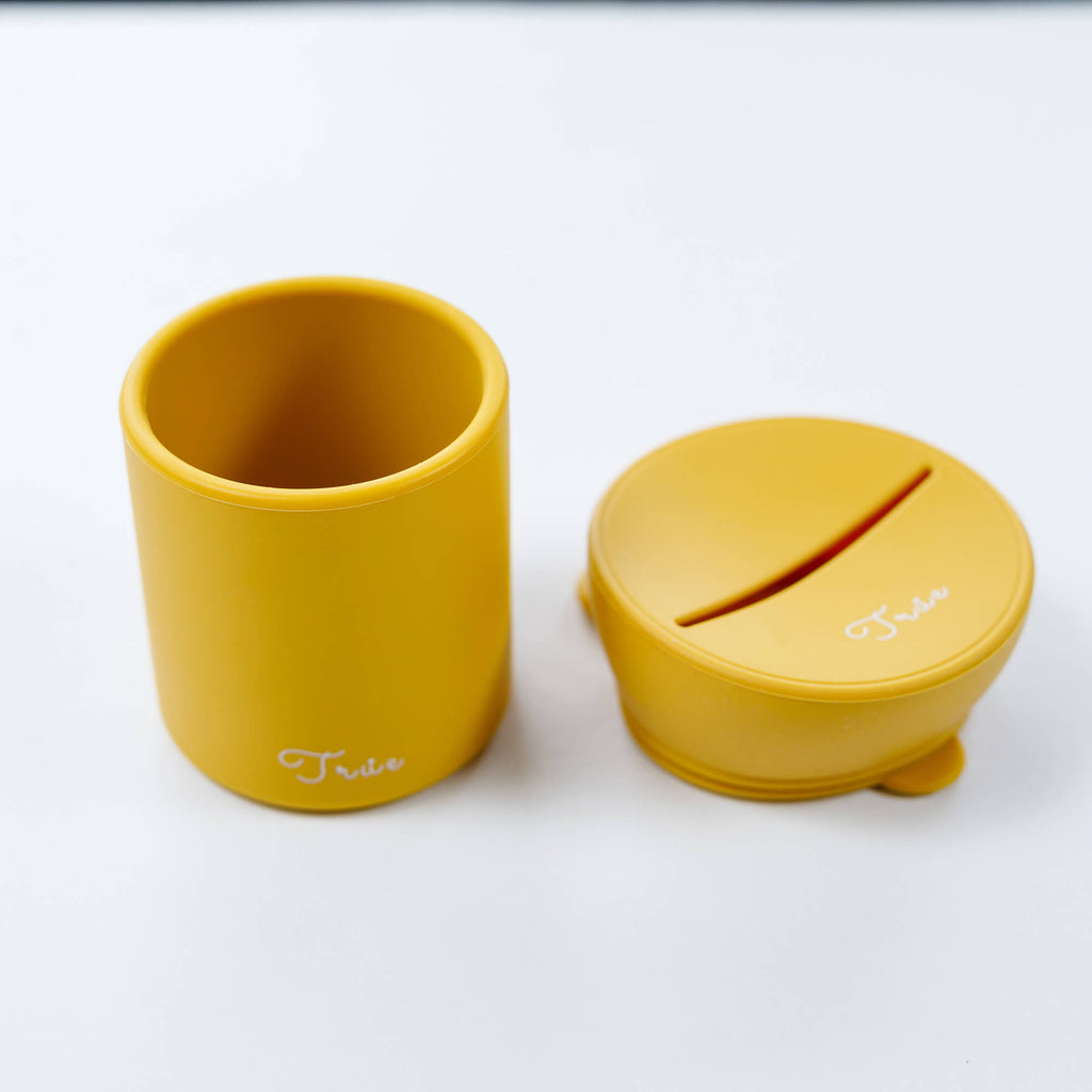 True silicone snack lid with cup in yellow color, BPA Free. The lid has a sliced opening in the middle.