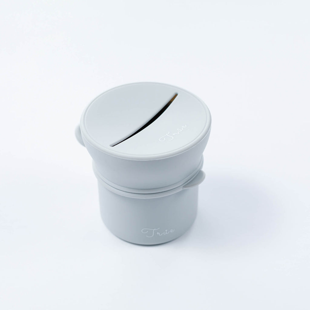 True silicone snack lid with cup in light grey color, BPA Free. The lid has a sliced opening in the middle.