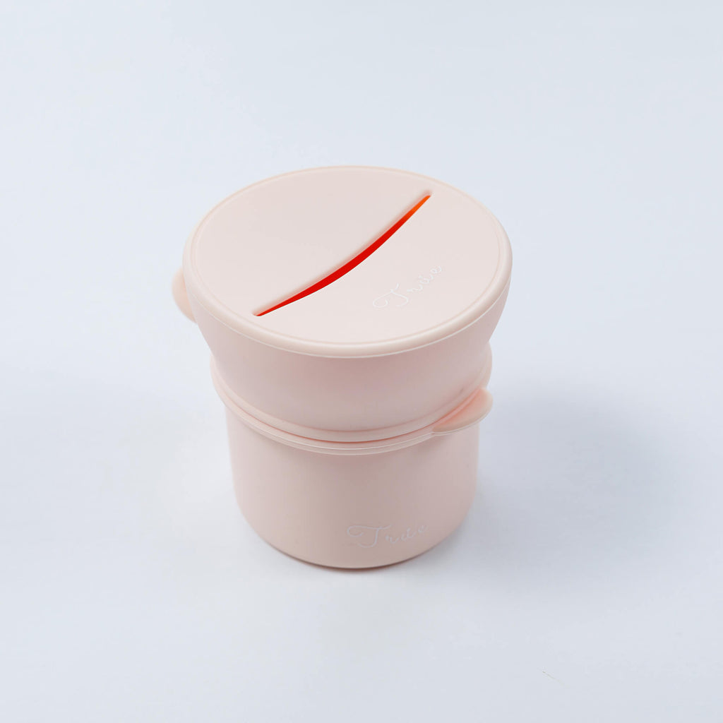 True silicone snack lid with cup in pastel pink color, BPA Free. The lid has a sliced opening in the middle.