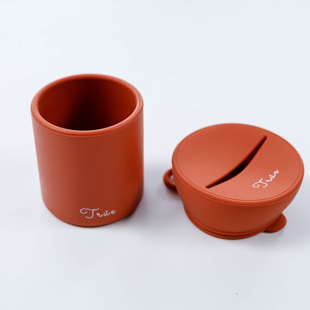 True silicone snack lid with cup in red color, BPA Free. The lid has a sliced opening in the middle.