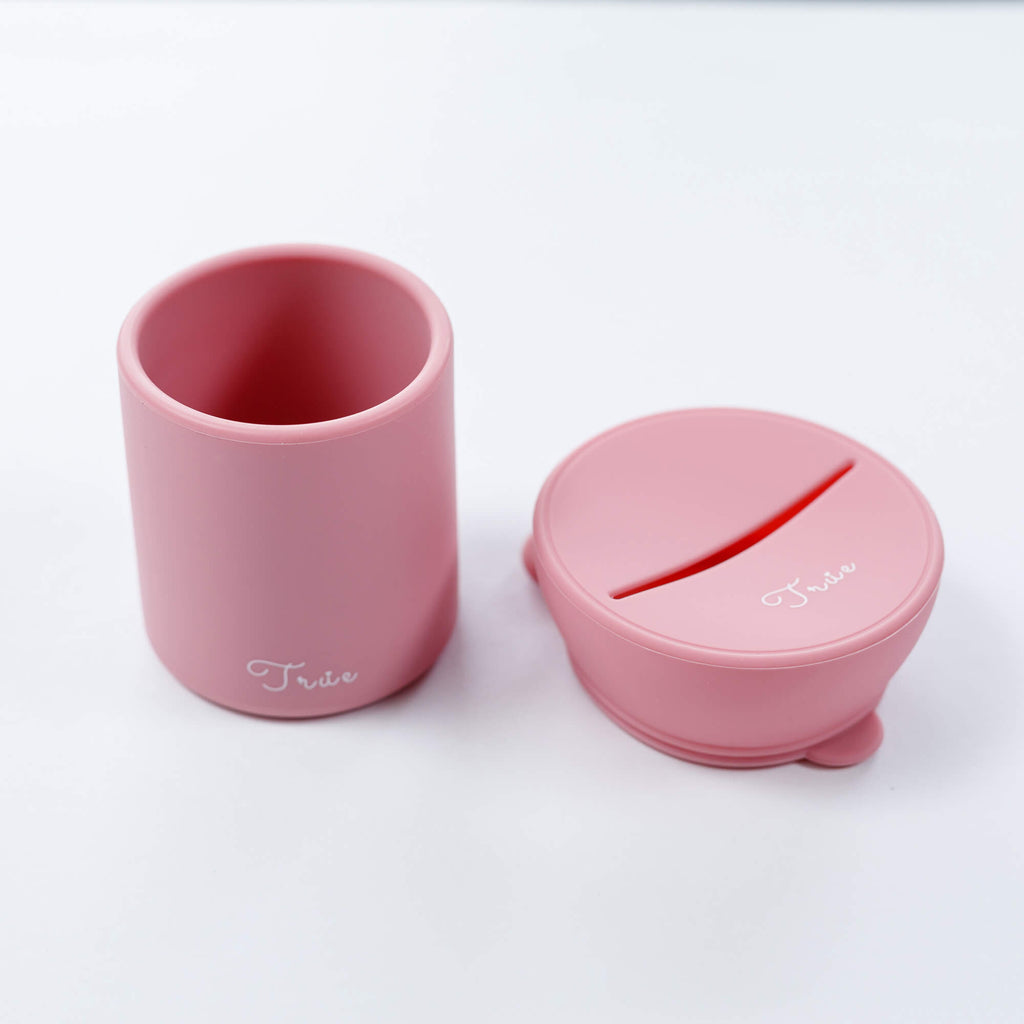 True silicone snack lid with cup in pastel pink color, BPA Free. The lid has a sliced opening in the middle.