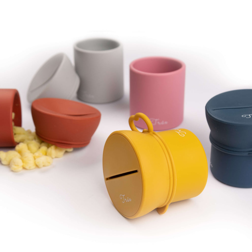 True silicone snack lid with cup in seven range of colors, BPA Free. The lid has a sliced opening in the middle.