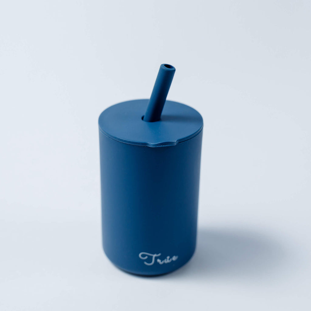 A cylindrical blue cup with a straw and a lid, featuring the word ‘True’ in a light font near the bottom.