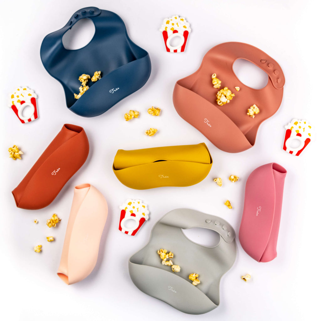 True's BPA-free, colorful Silicone Bucket Bibs with food-catching pockets. The bibs, featuring adjustable neck designs, come in nine different color shades.
