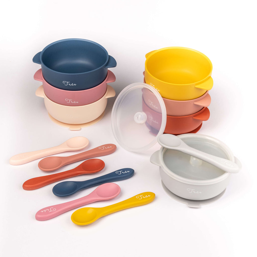 Variety of different color silicone suction bowl with two handles and a lid, including a spoon labeled with the brand ‘True'.