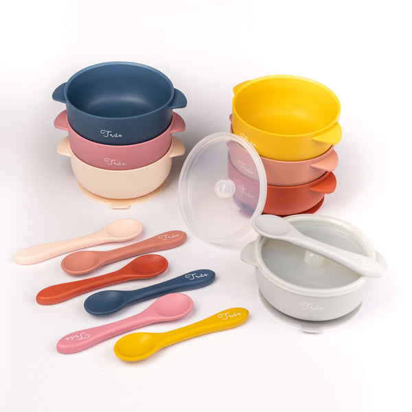 Variety of different color silicone suction bowl with two handles and a lid, including a spoon labeled with the brand ‘True'.