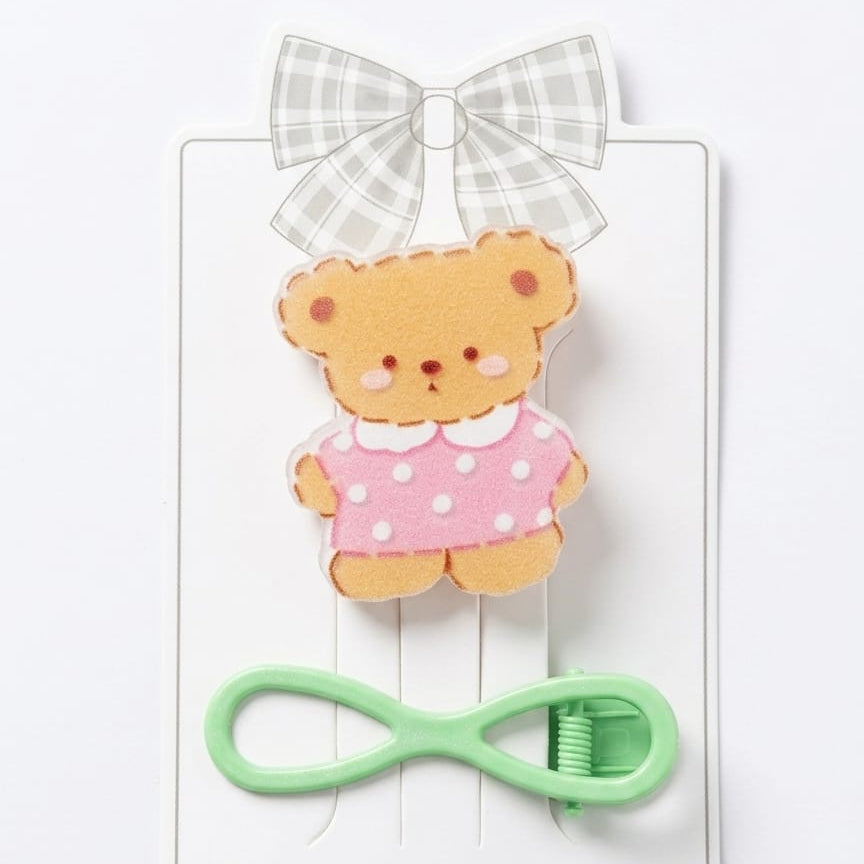 Teddy bear-shaped hair clip with a green clip on a white background