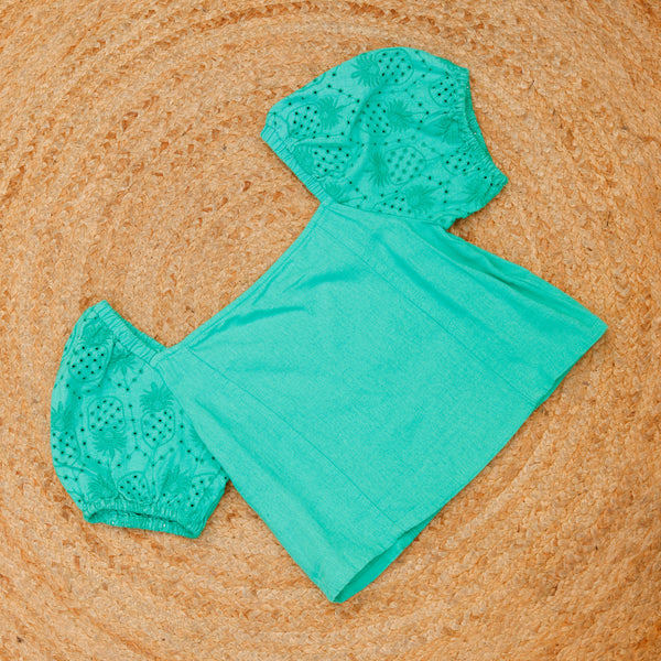 Teal swimsuit top and bottom set on a textured brown surface