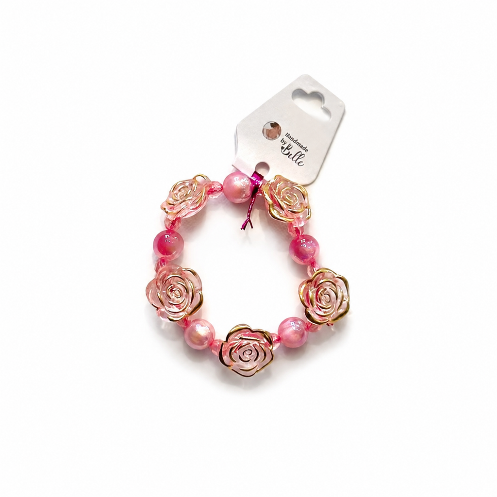 A pink beaded bracelet with rose-shaped metal charms and pink pearl-like beads, attached to a white paper hanger tag.