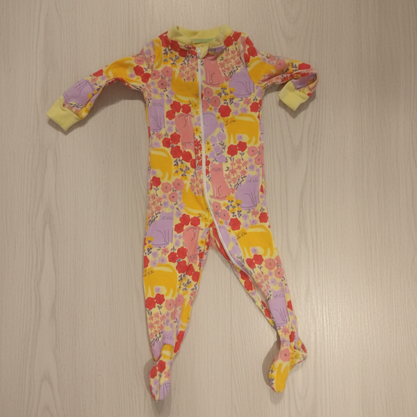 Colorful floral-patterned baby romper on a wooden surface