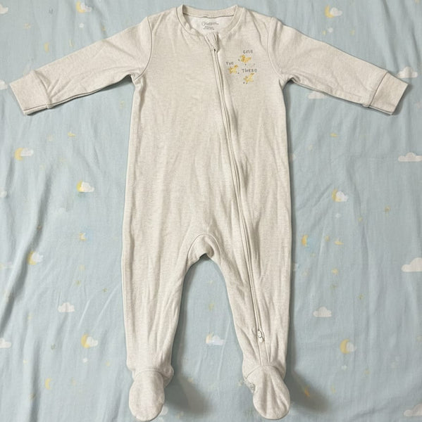 Baby onesie with footies on a blue blanket with cloud pattern