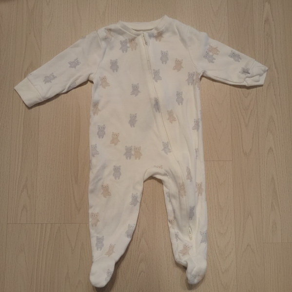 Baby onesie with star pattern on a wooden floor