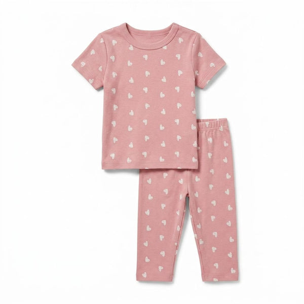 Pink pajama set with heart patterns on a white background