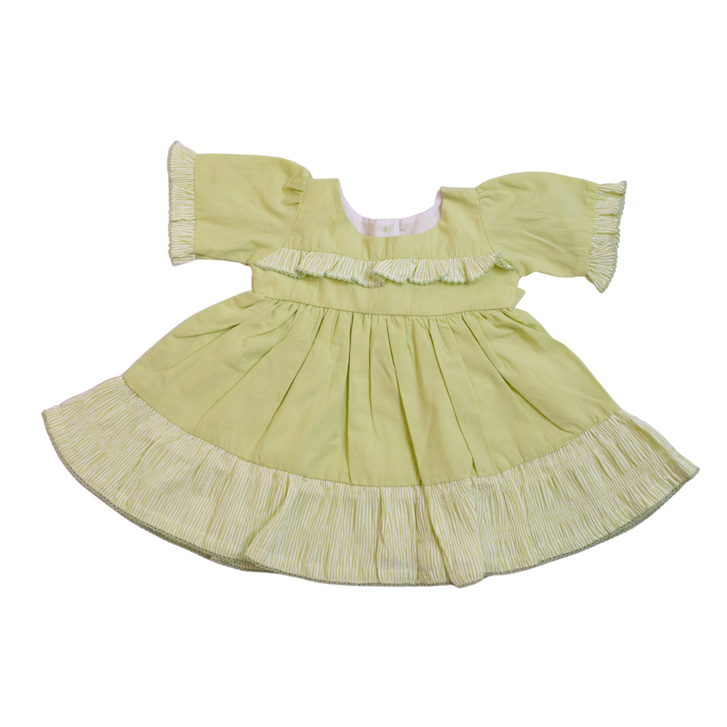 Light green dress with ruffled details on a white background