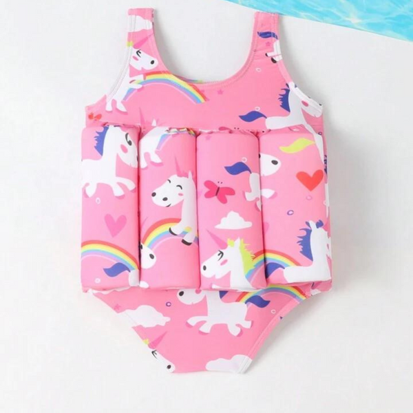 A pink one-piece swimsuit for babies with unicorn and rainbow print, featuring a frontal flotation device.