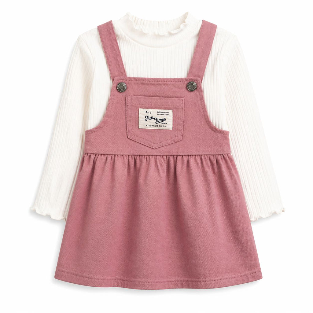 Pink denim dress with black buttons over a white long-sleeve shirt on a white background