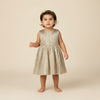 Young child wearing a gold dress against a beige background
