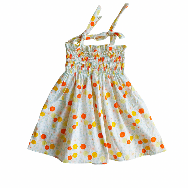 Baby girl floral smocked dress with orange and yellow details on a white background