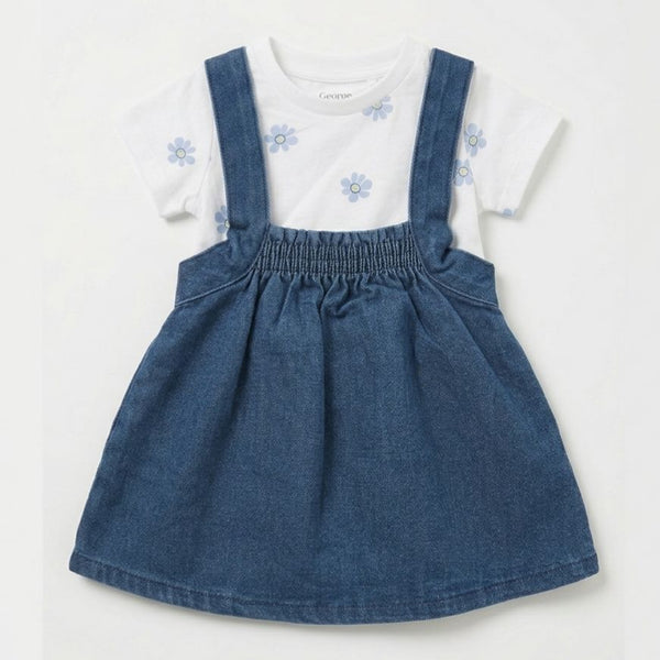 Children's outfit with blue denim pinafore and white shirt with floral design on a light gray background