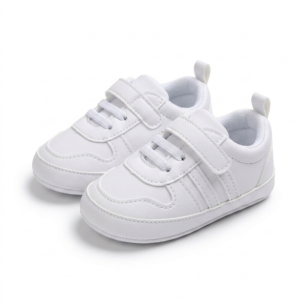 White children's sneakers with velcro straps on a white background
