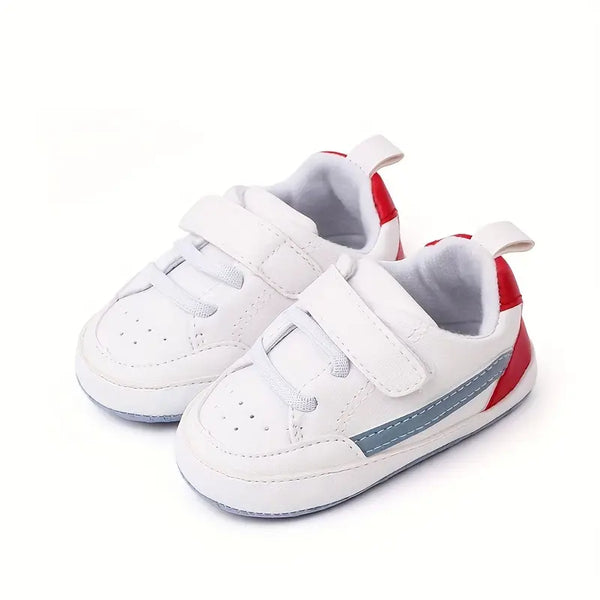 White children's sneakers with red and gray accents on a white background