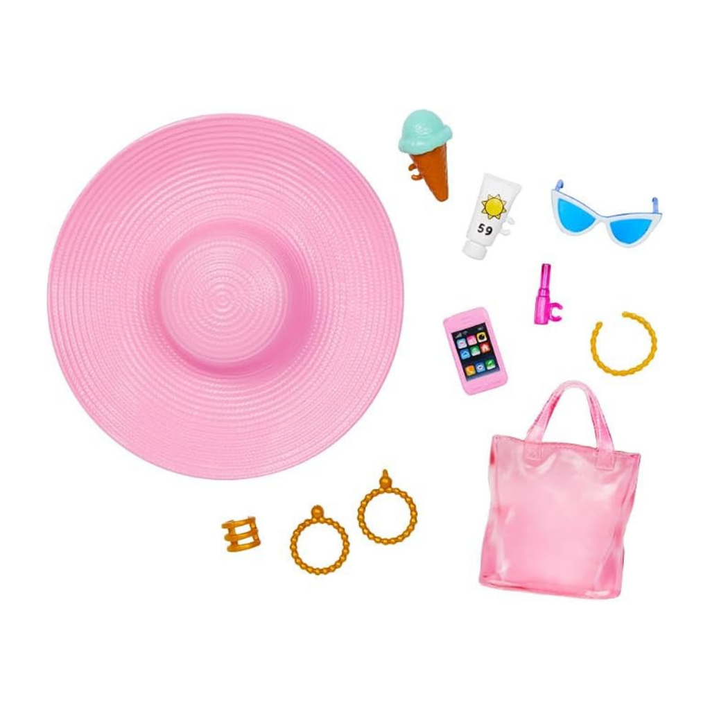 A pink toy accessory set laid out on a white background, including a large pink sun hat, a translucent pink tote bag, gold-tone jewelry pieces, blue sunglasses, a pink phone, a pink lip gloss tube, a small ice cream cone, a sunscreen tube, and a bracelet.