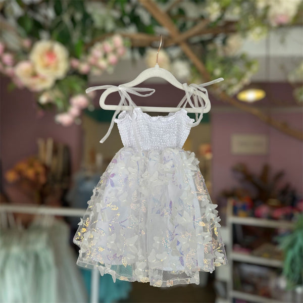 White floral dress on a hanger with a blurred indoor background