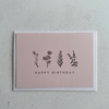 Pink birthday card with floral illustrations and 'Happy Birthday' text on a textured gray background