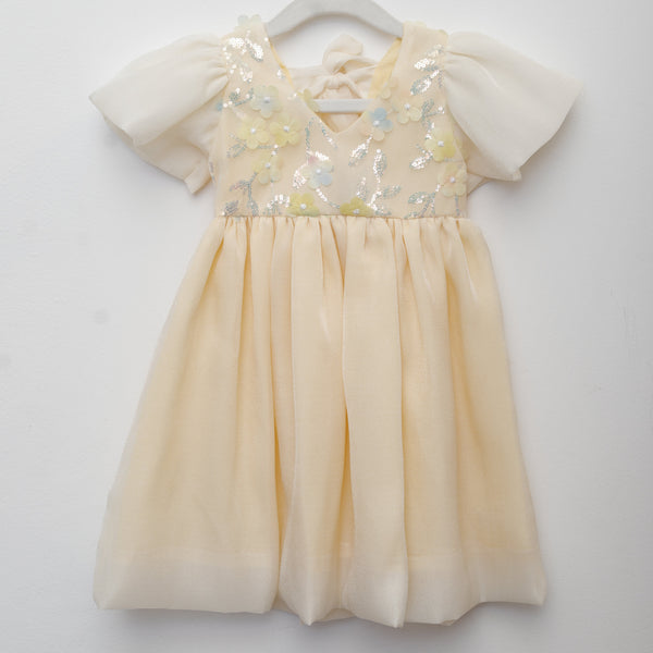 Yellow dress with floral embellishments on a white background
