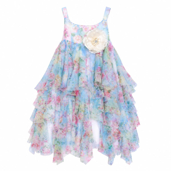 A sleeveless tiered ruffle dress for young girls, featuring a pastel blue, pink, and green watercolor floral print, with a large cream fabric flower applique on the chest.