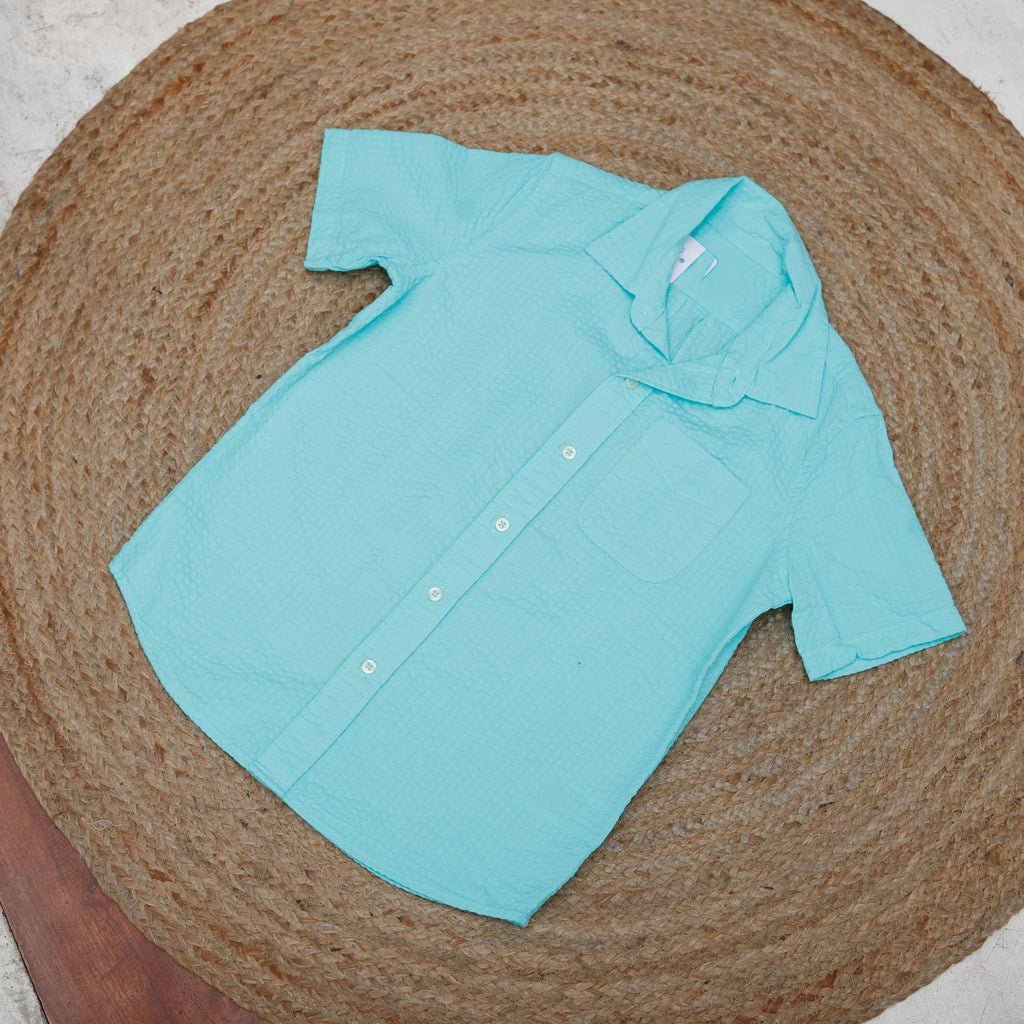 Light blue shirt on a textured brown surface