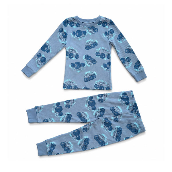 A two-piece children's pajama set featuring a long-sleeve top and matching pants in a dusty blue color, both printed with a repeating pattern of dark blue and light blue cartoon-style faces.