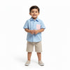 Child wearing a light blue shirt with a pink pocket and beige shorts on a white background