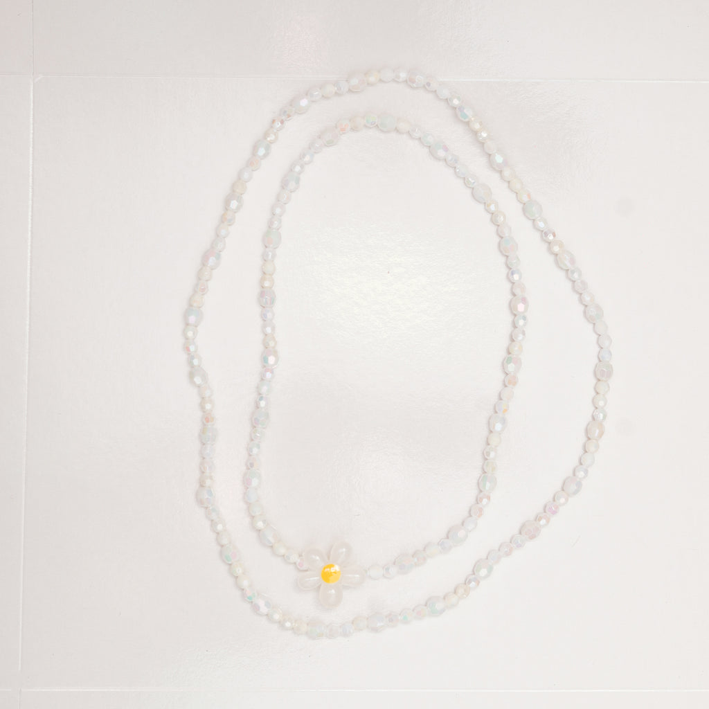 Pearl necklace with a yellow pendant on a light gray background