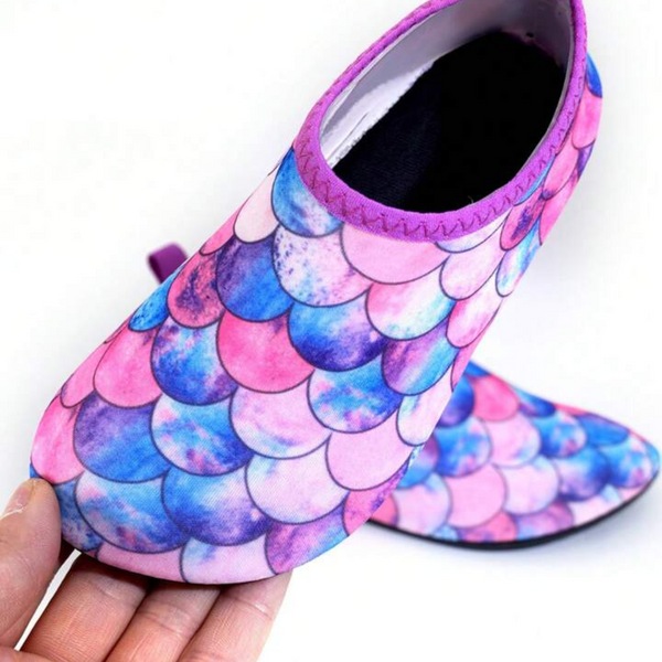 Children's swim shoes with a mermaid theme, featuring a scale pattern in shades of pink and purple.