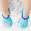 A pair of children's swim shoes with a rubber base and a sailing theme, featuring colorful sailboat patterns on a blue background.
