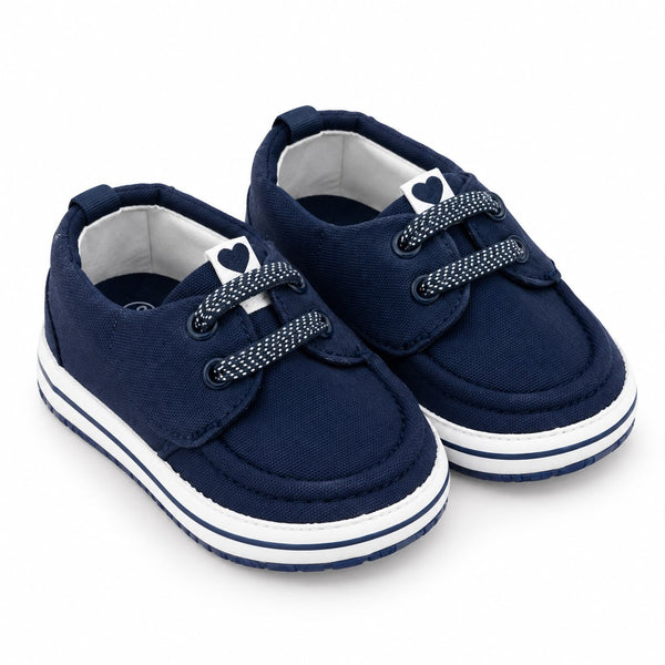 A pair of navy blue canvas baby shoes with white soles and decorative white laces featuring a small heart detail, shown on a white background.