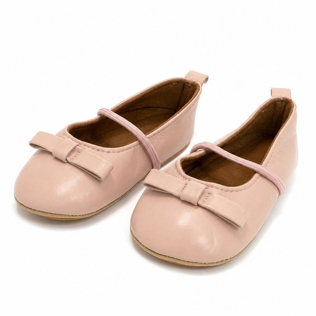 Pair of pink children's shoes with bows on a white background