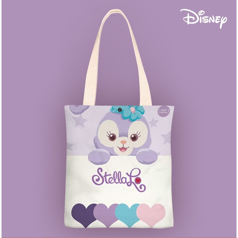 A Disney tote bag featuring a purple cartoon character peeking over a white surface with the name 'Stella' written below, set against a solid lavender background. The Disney logo is visible in the top right corner.