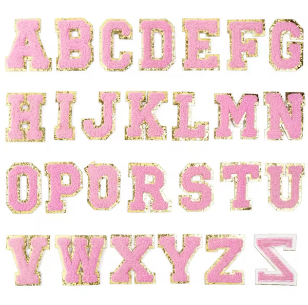 A set of light pink embroidery fabric letter patches, each letter is presented in a different font style, and they are all embroidered in a pink color.