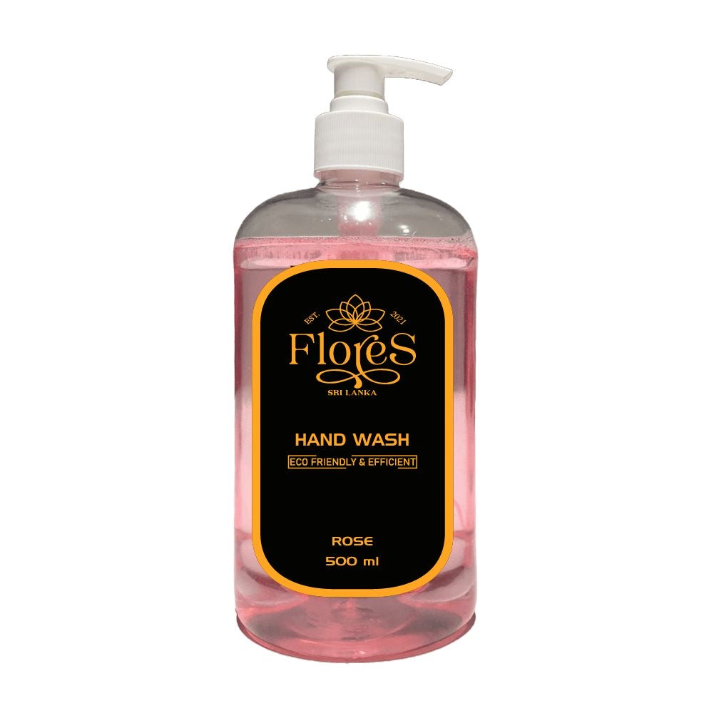 A clear plastic bottle with a pump dispenser containing pink handwash labeled 'Flores Hand Wash' with text indicating rose scent and 500ml volume.