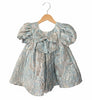 Children's dress with a bow on a hanger against a white background