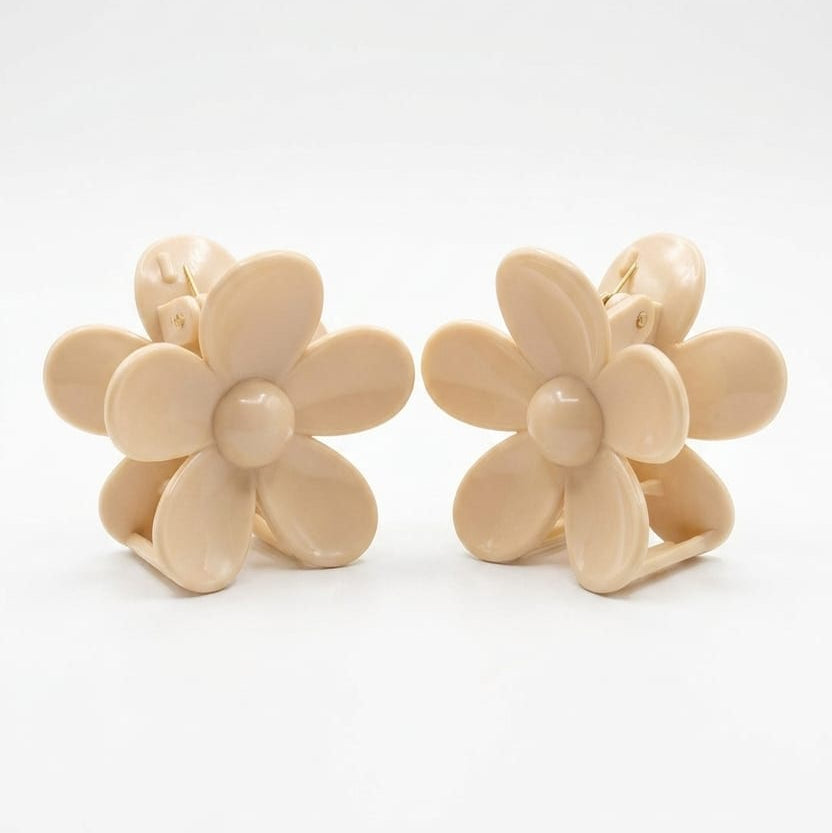Pair of beige flower-shaped clips on a white background