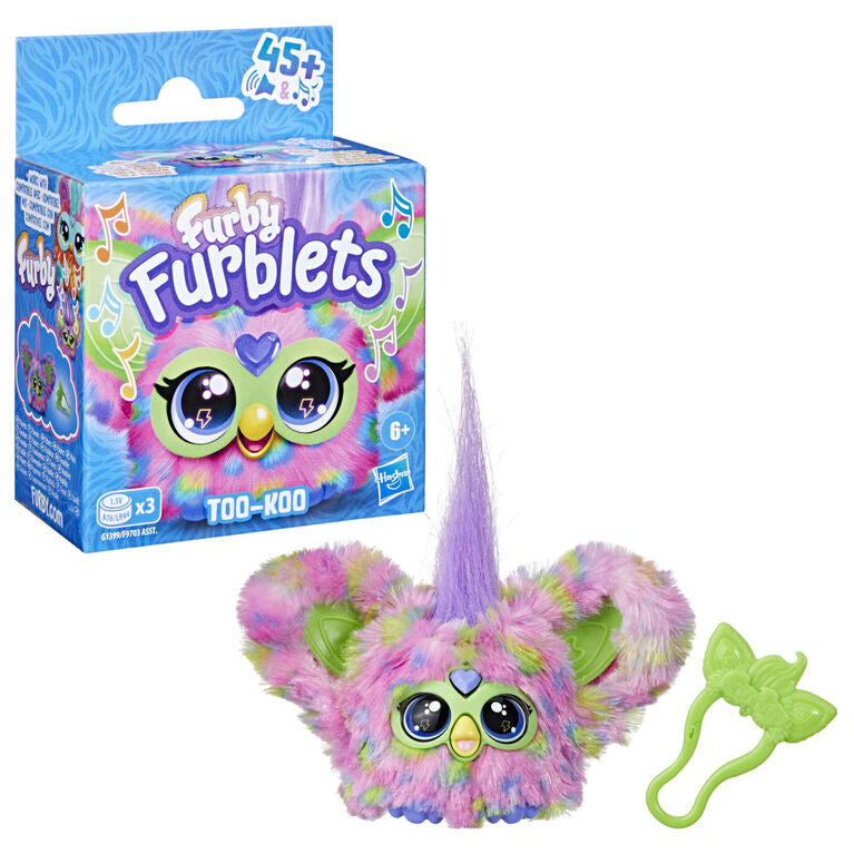 Packaging and toy version of Furby Furblets TOO-KOO with multicolored fur and a purple horn, featuring large eyes and a small keychain clip.