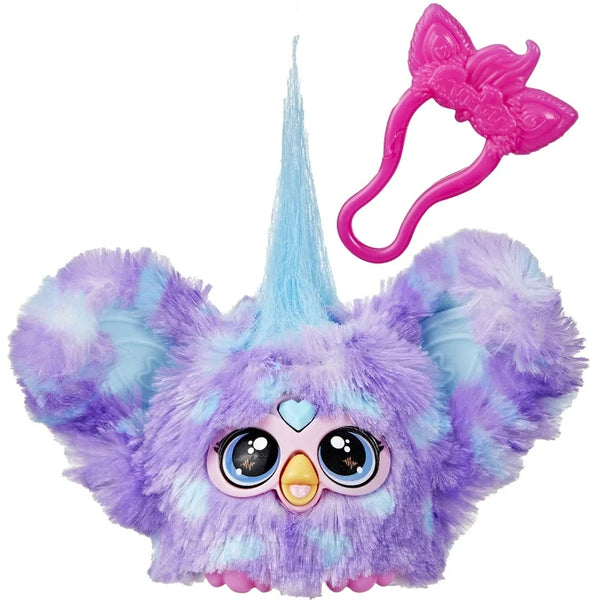 A small plush toy resembling a Furby with purple and blue fur, big eyes, and a pink accessory on its head.