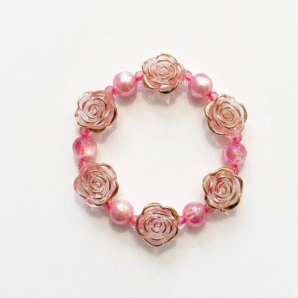 A pink and rose gold beaded bracelet featuring rose-shaped metal charms and translucent pink beads, displayed on a clean white background.