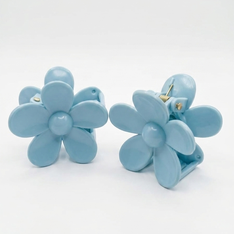 Pair of light blue flower-shaped earrings on a white background