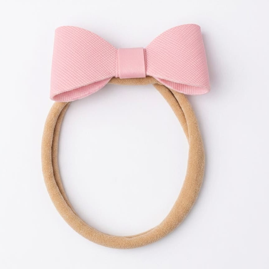 Pink bow headband on a white background
